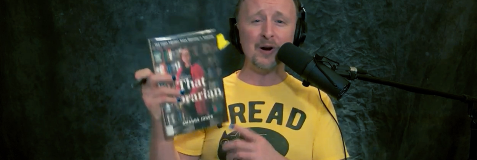 Paul Cram holding up the book "That Librarian" by Amanda Jones